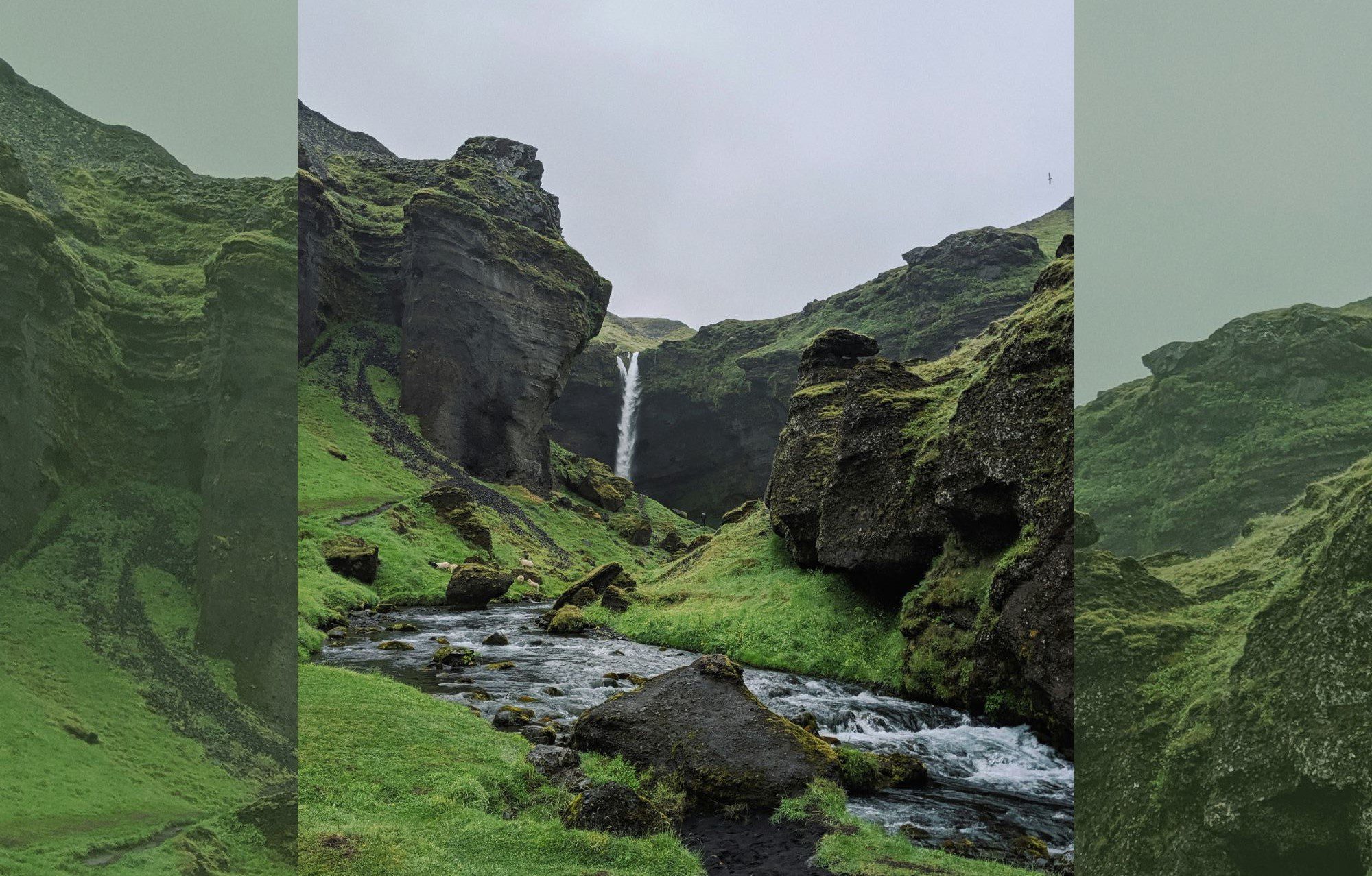 a green rocky landscape with waterfall flowing gently through the middle